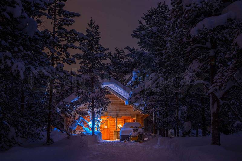Winter windless night. Dense spruce forest. Wooden house lighted and a lot of snow. Car and snowmobile are there, stock photo