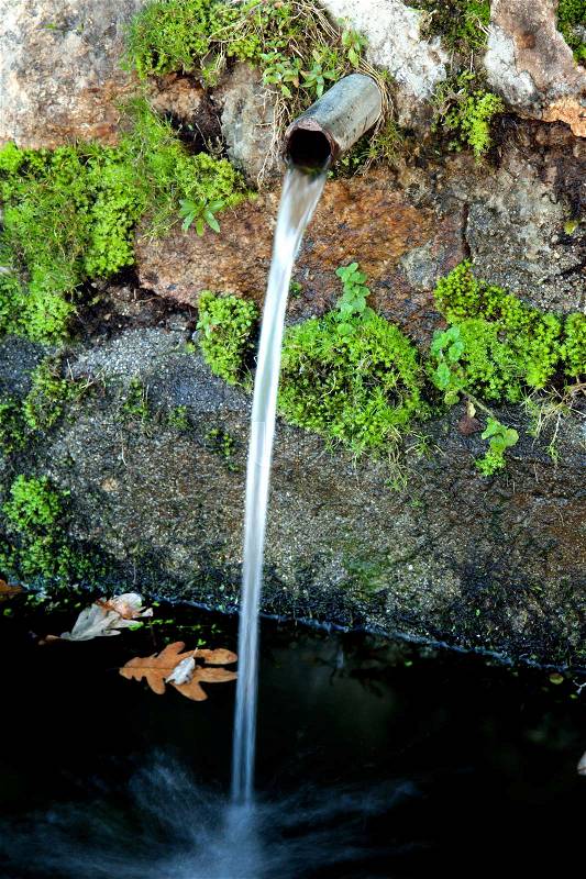 Pipe clean water pouring from a natural source, stock photo