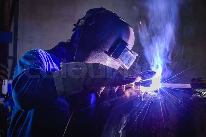 Welding steel structures and bright sparks in construction industry, stock photo