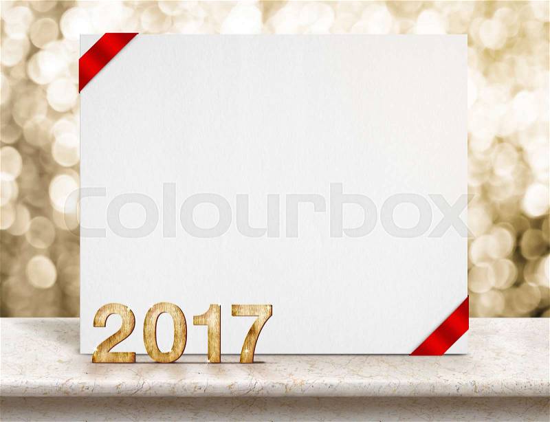 2017 year wood number and white card with red ribbon in perspective room with sparkling bokeh wall on marble table top,Leave space for display or montage of your design, stock photo
