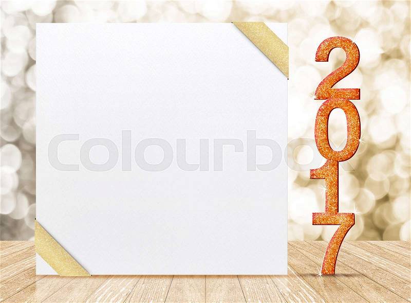 2017 New year glitter number and white card with gold ribbon in perspective room with sparkling bokeh wall and wooden plank floor,leave space for display of product, stock photo