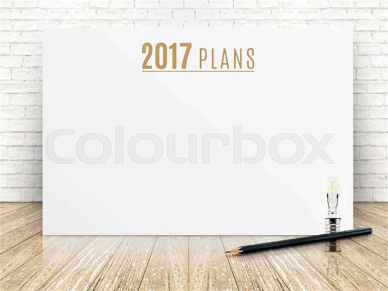 2017 plans year text on white paper poster with black pencil and lightbulb on wood plank floor and white brick wall,Business presentation mock up for adding your list, stock photo