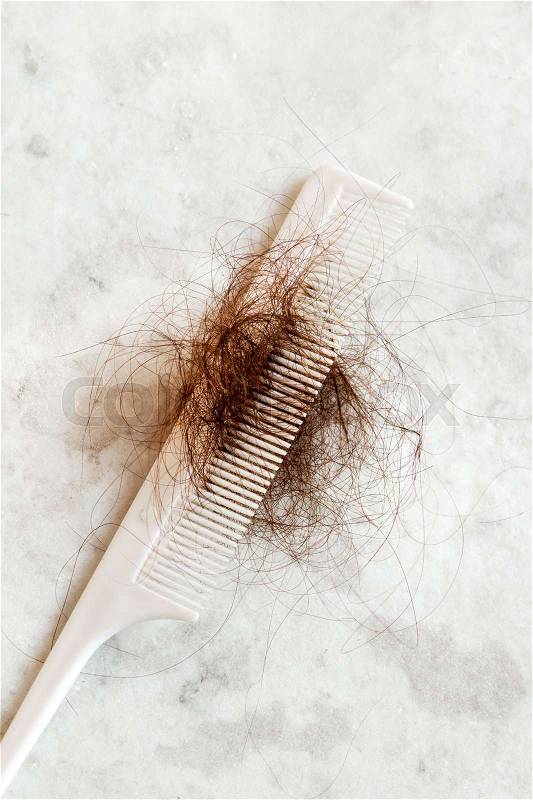 Hair on white comb close up - hair loss problem concept, stock photo