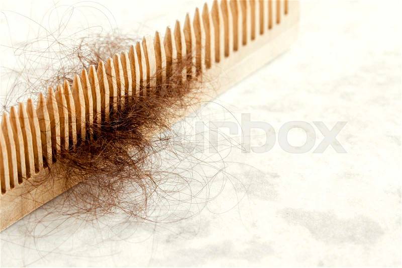 Hair on wooden comb close up - hair loss problem concept, stock photo