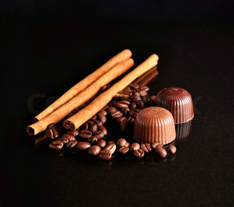 Cinnamon sticks ,coffee beans and candy on black background, stock photo