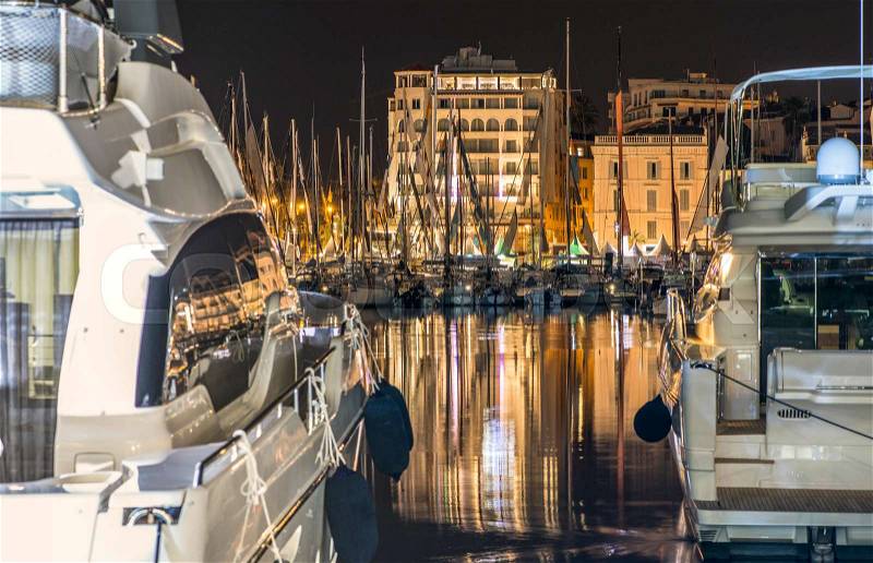 Yachts in the cannes bay at night. Illuminated buildings , stock photo