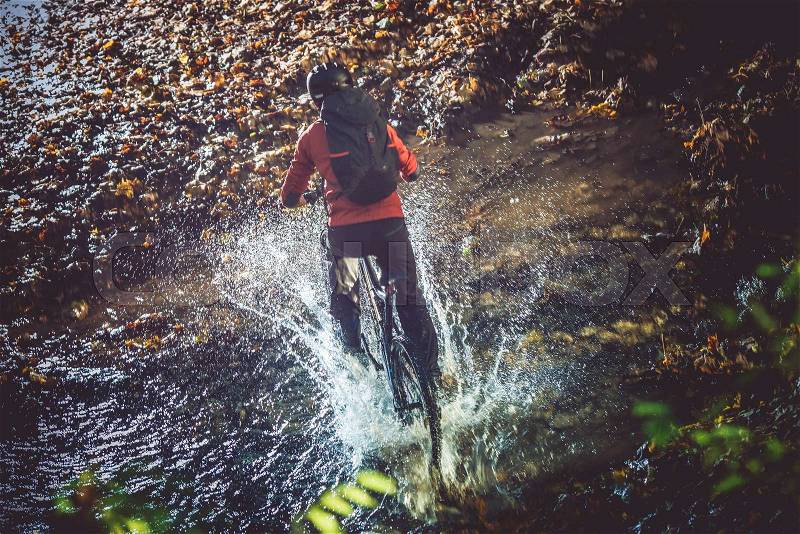 Bike Mountain River Crossing at High Speed with Splashing Water. Mountain Biker, stock photo