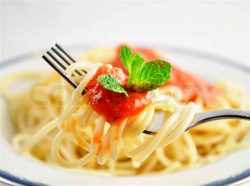 Spaghetti on a fork with tomato sauce, stock photo
