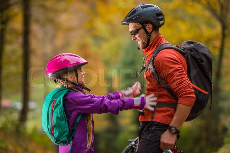 Father Daughter Bikes Trip. Caucasian Men and His Daughter Both Wearing Bike Safety Helmets. Daughter About to Give Father Hug. Family Theme, stock photo