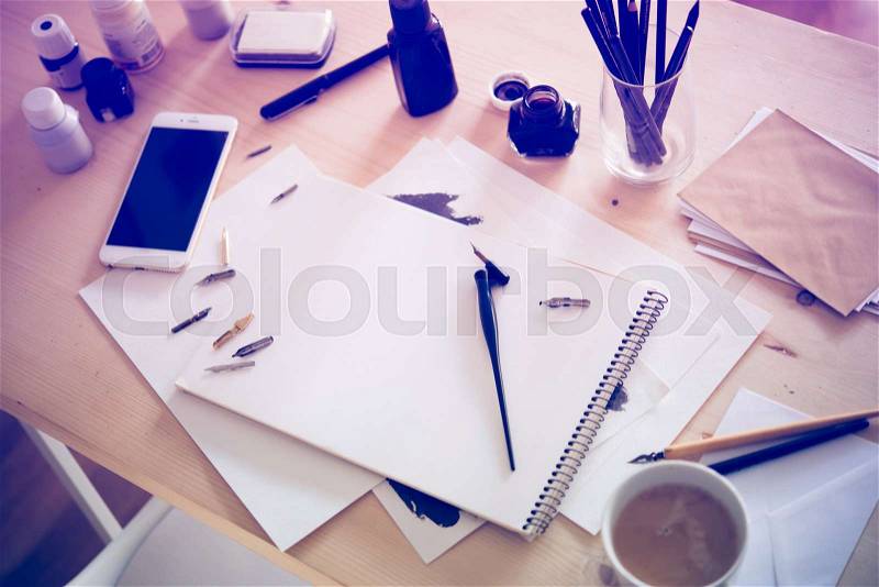 Artist\'s desk and workspace. Paper, ink and calligraphy pens. Creative process, lettering art workshop details close-up, stock photo