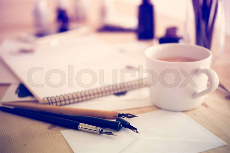 Artist\'s desk and workspace. Paper, ink and calligraphy pens. Creative process, lettering art workshop details close-up, stock photo