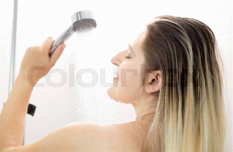 Rear view closeup portrait of beautiful woman with long hair at shower, stock photo