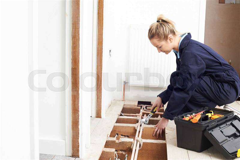 Female Plumber Fitting Central Heating System, stock photo