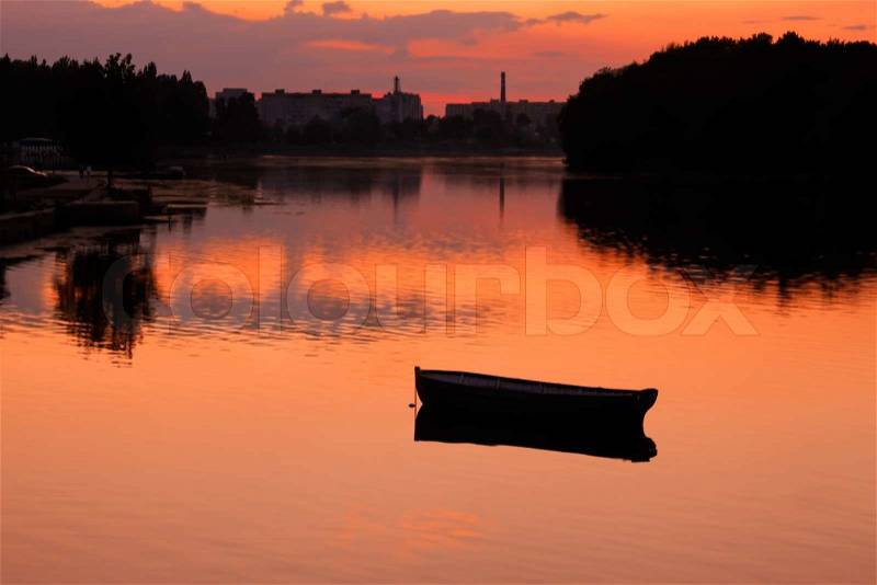 View anchored boat in the reservoir after sunset in quiet summer weather. Khmelnitsky,, stock photo