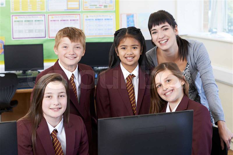 Portrait Of Elementary School Pupils With Teacher In Computer Class, stock photo