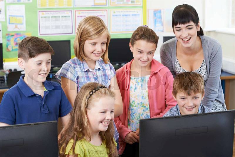 Elementary School Pupils With Teacher In Computer Class, stock photo