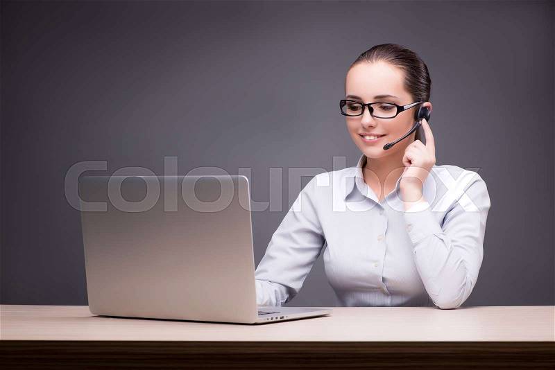 Call center operator working at her desk, stock photo