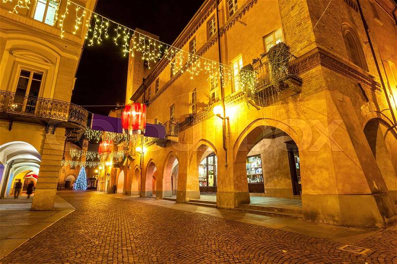Evening street in old town of Alba, Italy decorated and illuminated for Christmas holidays, stock photo