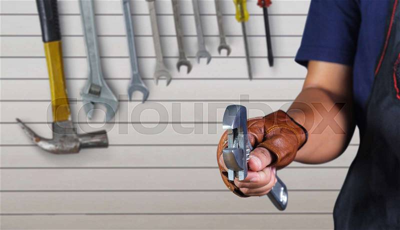 Cropped view of Hand with wrench, Motorcycle mechanic, stock photo