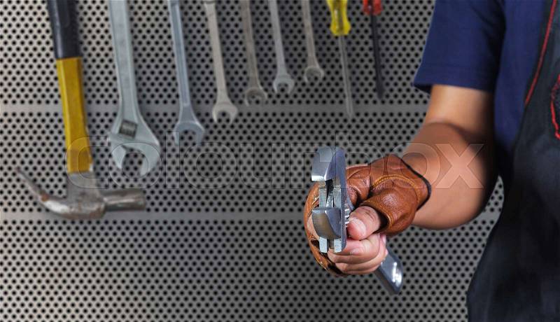 Cropped view of Hand with wrench, Motorcycle mechanic, stock photo