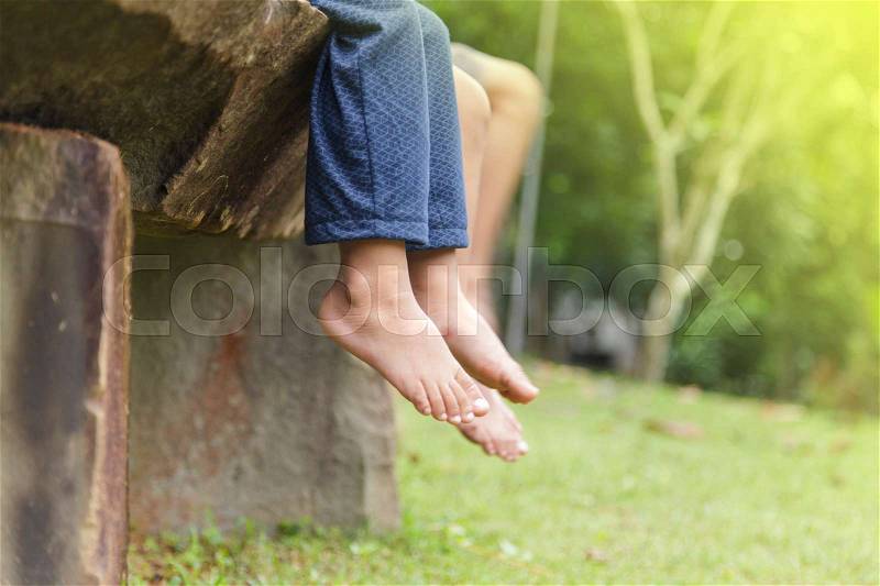 Children legs barefoot, Kids sitting dangling their feet in summer concept for family, friends, stock photo