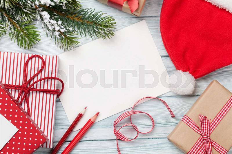 Christmas greeting card and gift boxes on wooden table. Top view with copy space. Gift wrapping, stock photo
