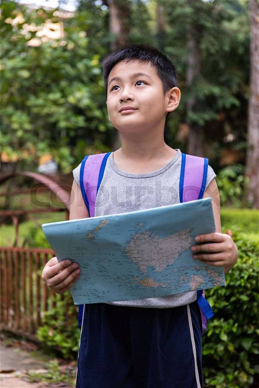 Asian Chinese little boy holding map in the forest searching for direction, stock photo