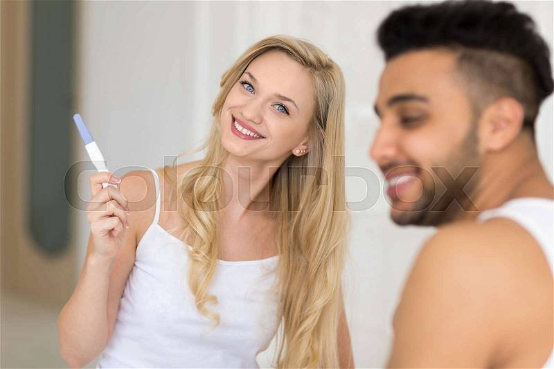 Young Couple Sitting In Bed, Happy Smile Woman Show Excited Surprised Man Positive Pregnancy Test Lovers Bedroom, stock photo