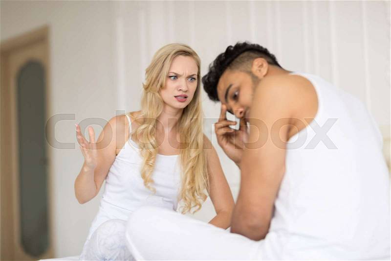 Young Couple Lying In Bed, Having Conflict Relationships Problem, Sad Negative Emotions Unhappy Hispanic Man And Woman Lovers In Bedroom, stock photo