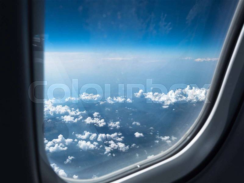 View of the cloudy sky from the airplane\'s window. Picture of the blue sky with white clouds. The foto that was made above the white cumulus, stock photo