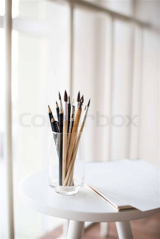 Creative artist\'s workspace, artistic paint brushes and clean paper in studio interior, painting tools, stock photo