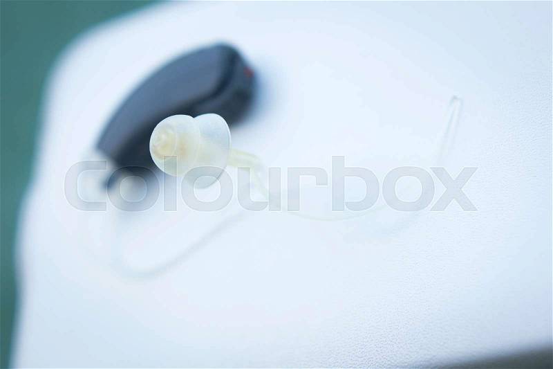 Modern digital hearing aid device for deaf and hard of hearing patients, stock photo