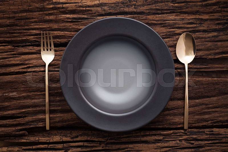 Black empty bowl fork spoon on wooden table background still life vintage flat lay, stock photo