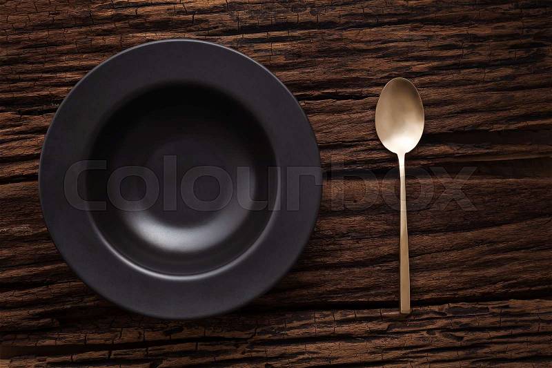 Black empty bowl spoon on wooden table background still life vintage flat lay, stock photo