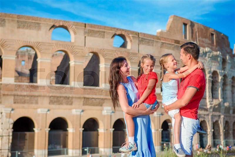 Happy family in Europe. Parents and kids in Rome over Coliseum background. Italian european vacation together, stock photo