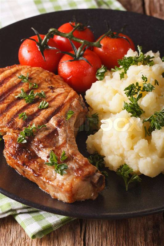 Grilled pork chop with mashed potatoes on a plate close-up. vertical\, stock photo