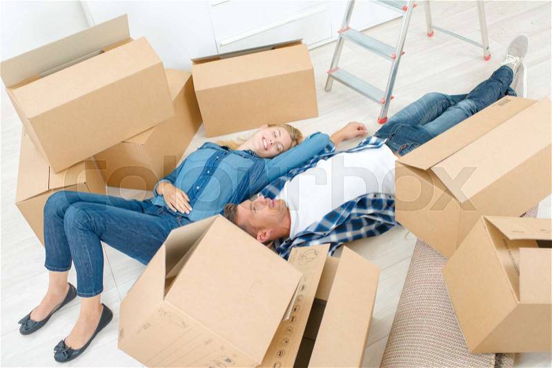 Couple exhausted by house move, stock photo