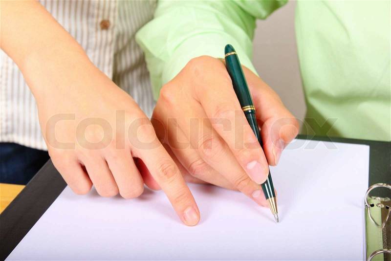 Two businesspeople signing a letter, stock photo