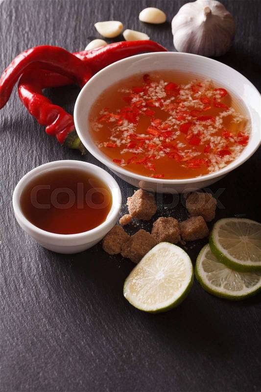 Vietnamese spicy sauce Nuoc Cham with the ingredients in a bowl close-up. vertical\, stock photo