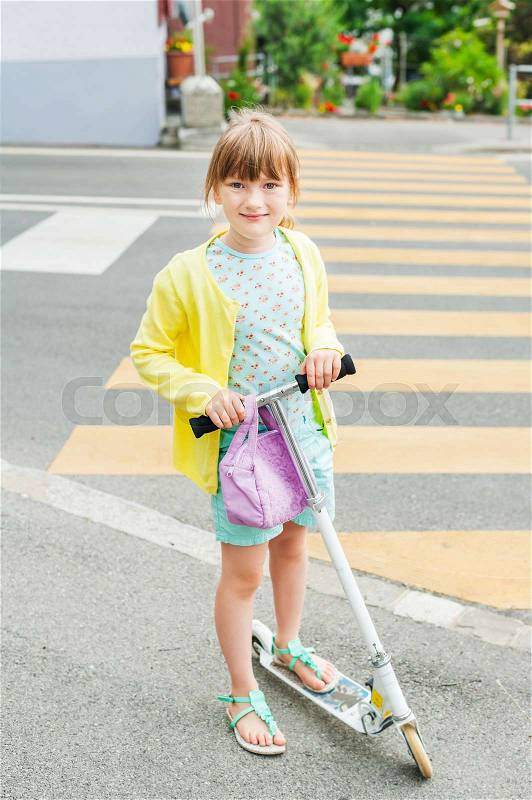 Pretty little girl is going to cross the road alone, stock photo