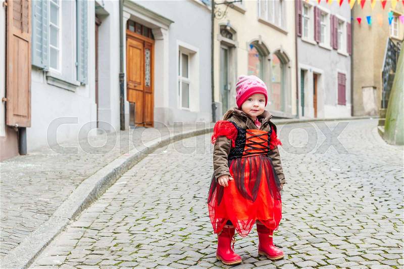 Cute little girl playing in a city, wearing princess costume, stock photo