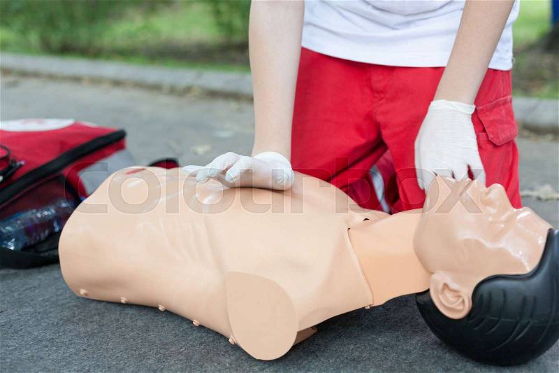 Paramedic practicing Cardiopulmonary resuscitation - CPR on a dummy. Cardiac massage, stock photo