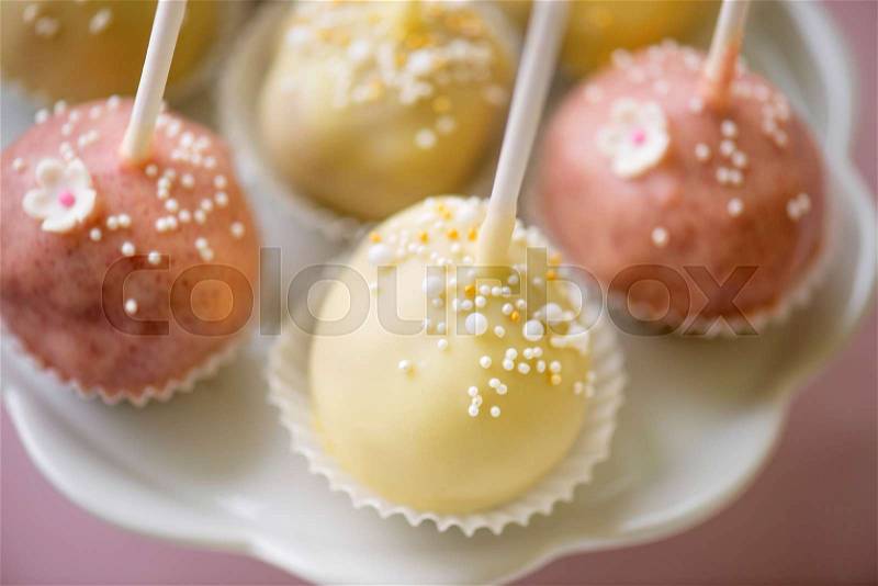 Table with white and pink cake pops on cakestand, close up. Candy bar, stock photo