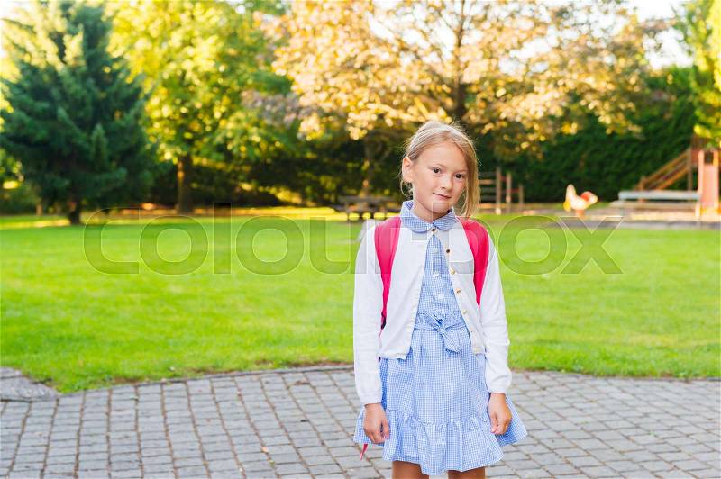 A young little girl preparing to walk to school, stock photo