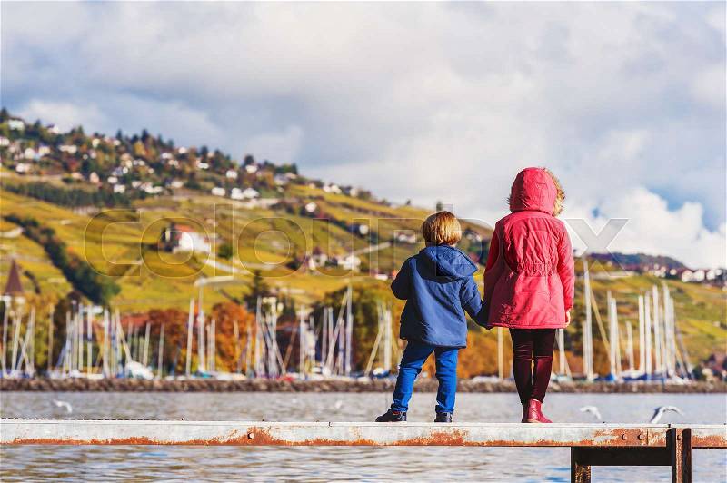 Two kids admiring amazing view of Lake Geneva, Switzerland, back view, stock photo