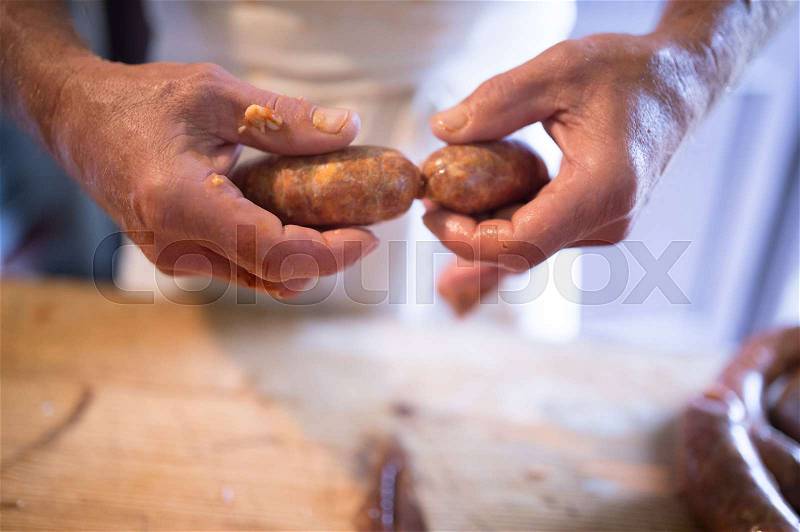 Hands of unrecognizable man making sausages the traditional way at home. Close up, stock photo