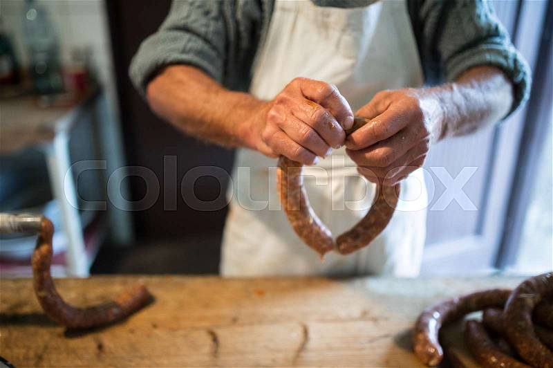 Hands of unrecognizable man making sausages the traditional way at home. Close up, stock photo