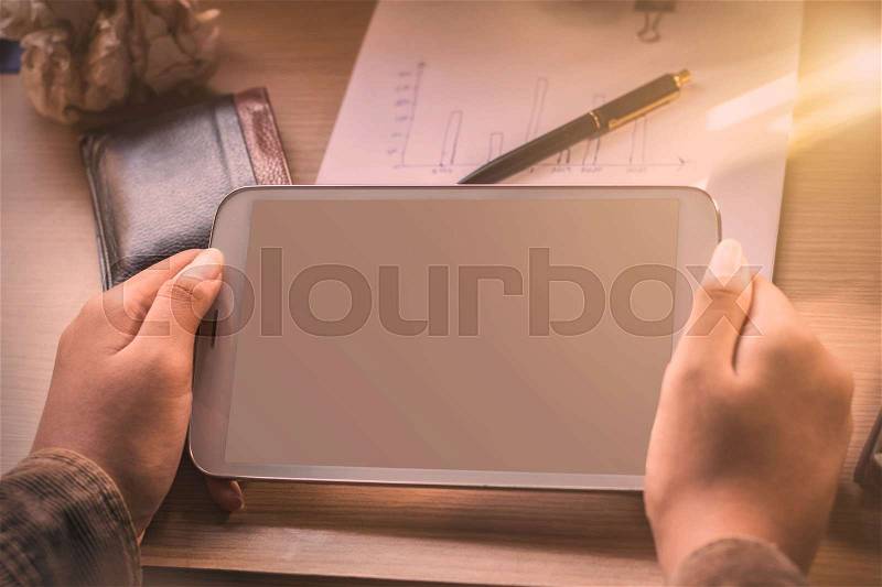 Hand of woman holding a tablet and desktop devices, stock photo