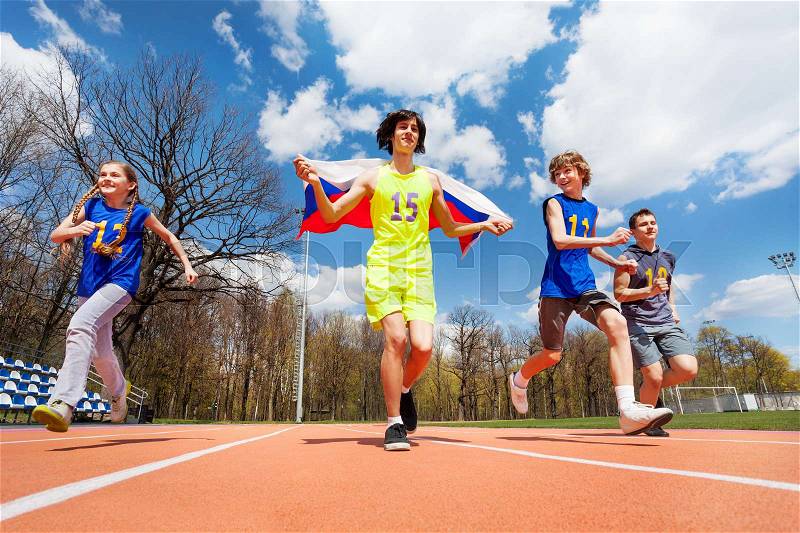 Happy teenage sprinters running with Russian flag in the stadium, stock photo