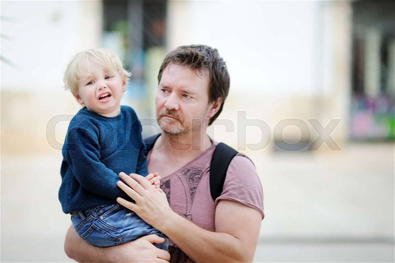 Middle age father with his little son walking outdoors. Fatherhood concept, stock photo